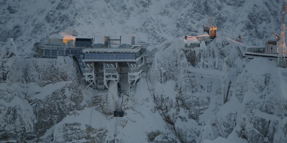 Lights glow on a mountain peak station in winter
