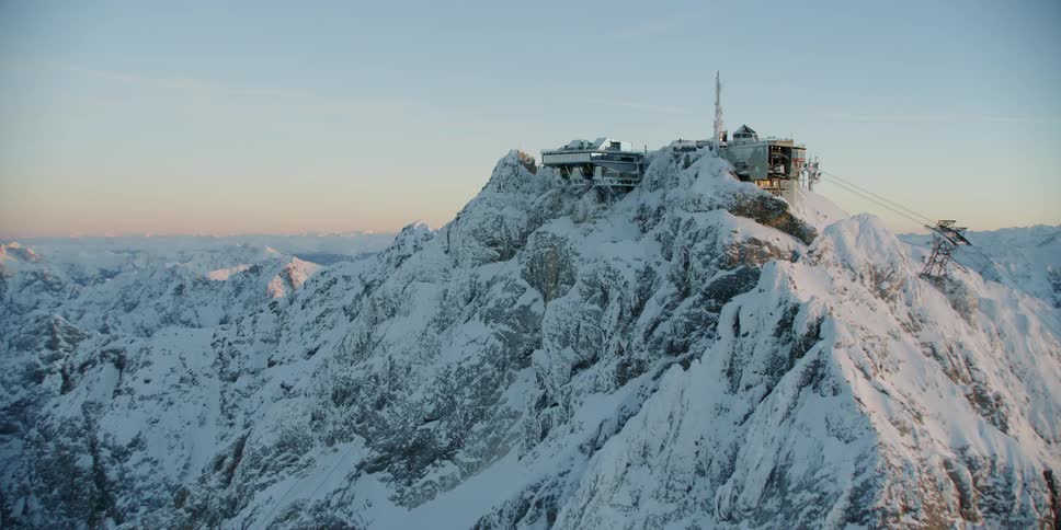 A building sits perched on a snowy mountain peak