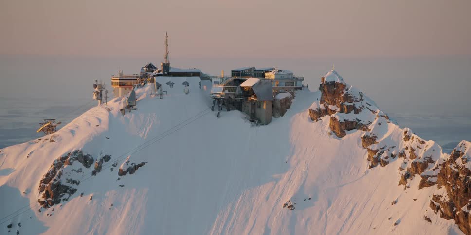 A large building is built onto a large snowy mountain