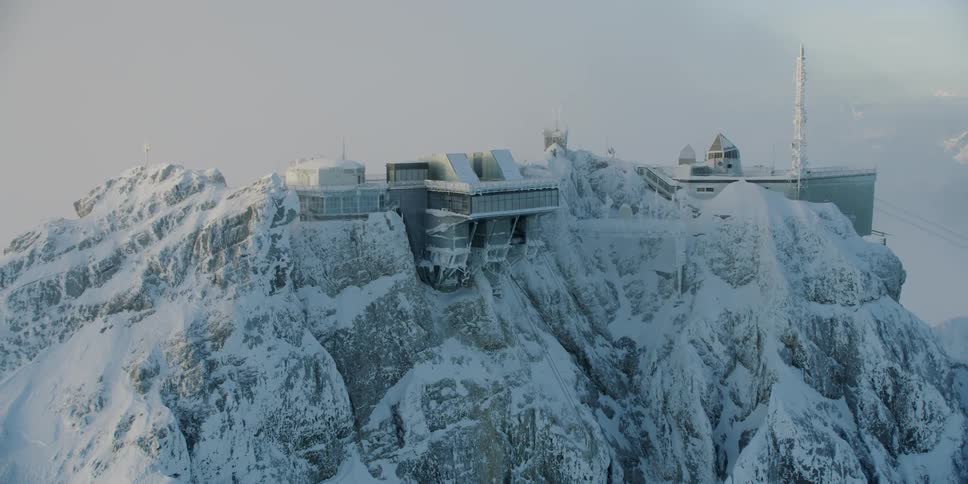 A building sits on a snowy mountain peak