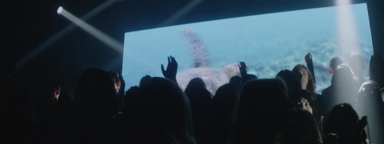 A choir sings in front of a projection