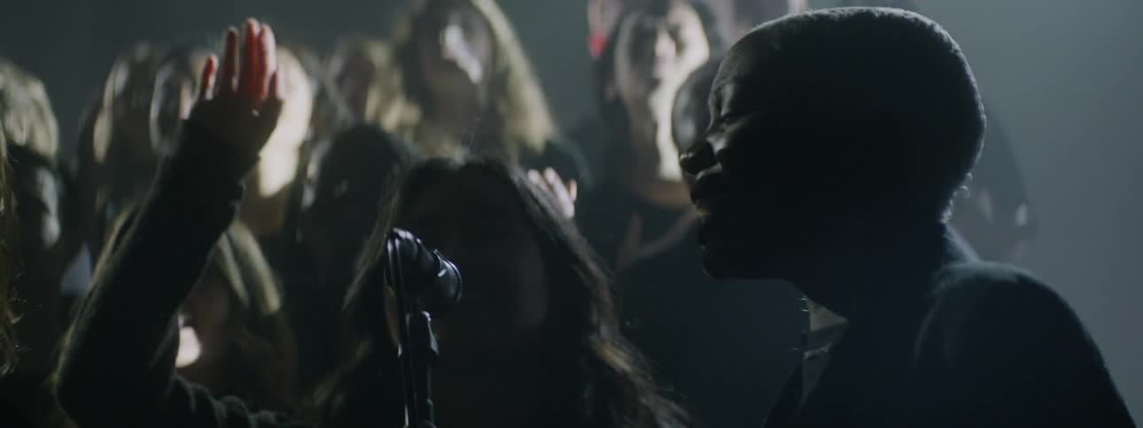 A choir sings on a stage with flashing lights