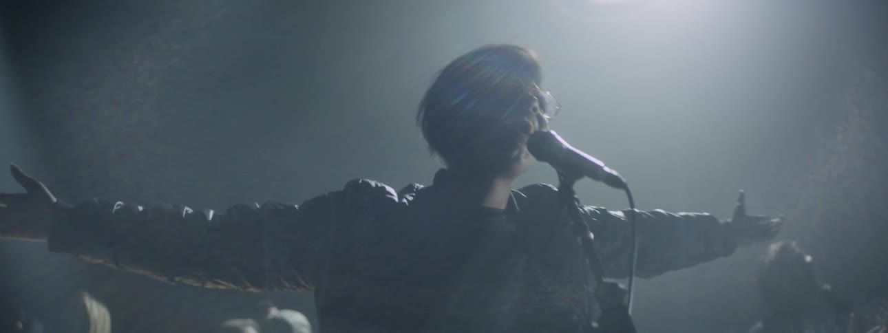 A woman is singing on the dark stage