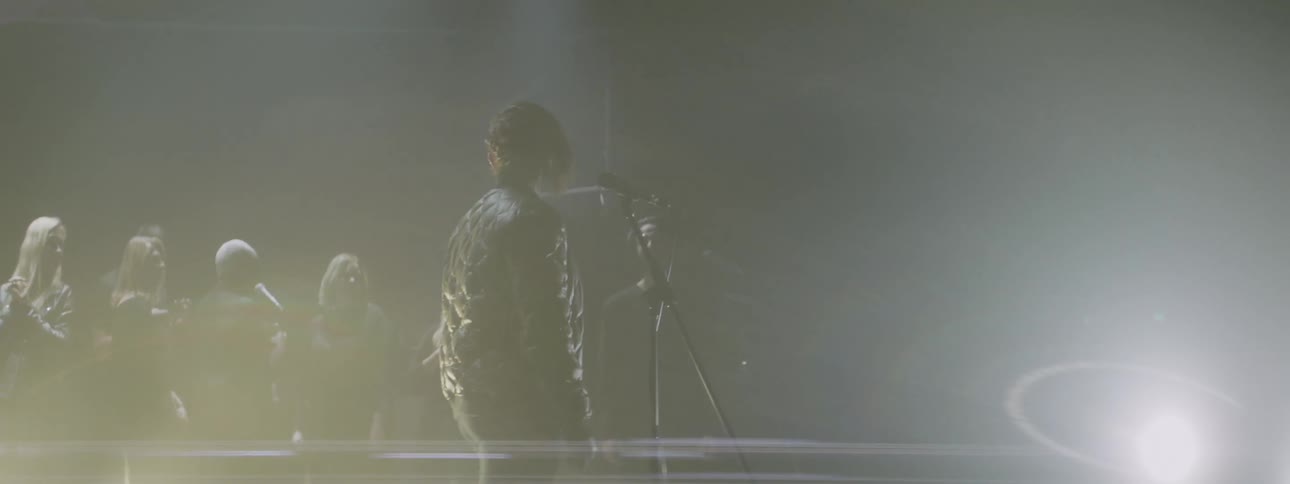 A spotlight shines on a performing choir