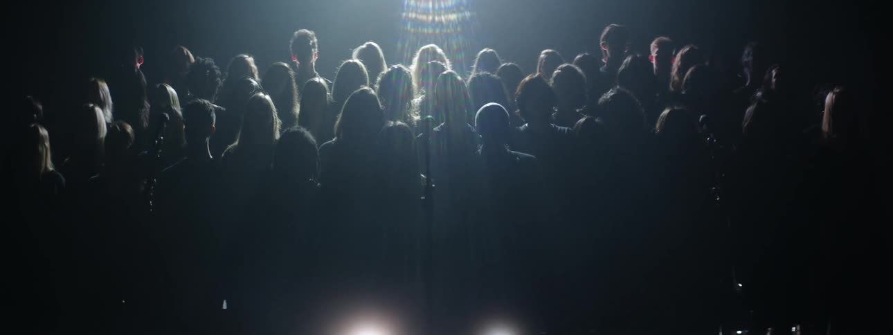 A group of people stand together in the dark