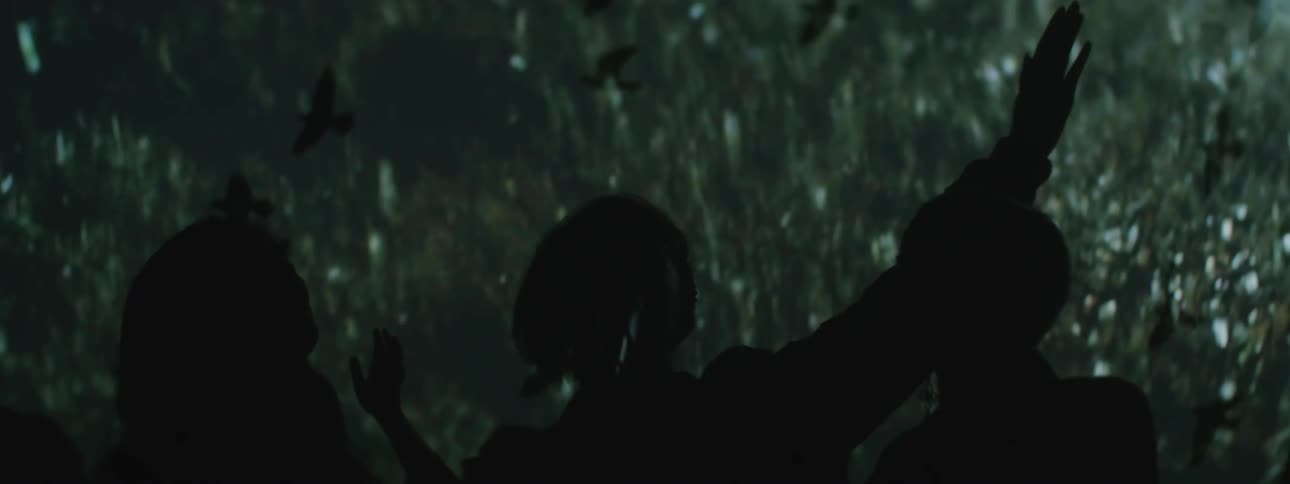 A choir sings in front of projected photos