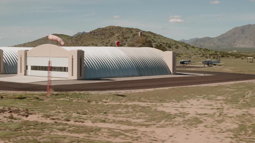 Airplane hangars sit in a rural field