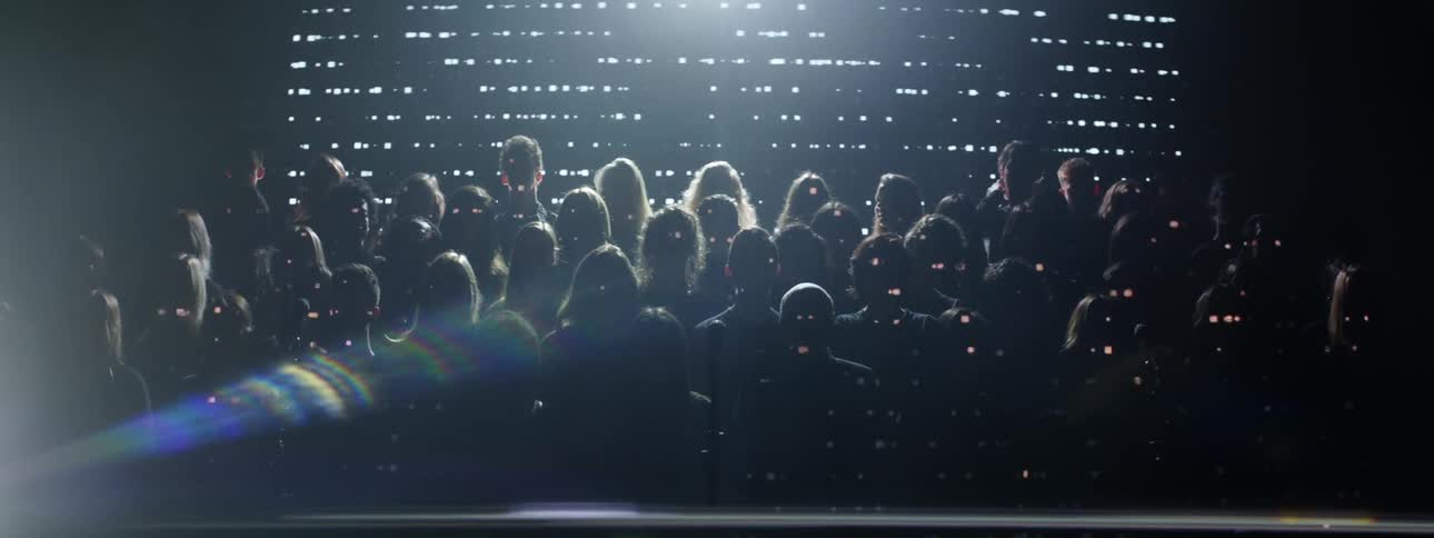 A choir performs on stage with flashing lights