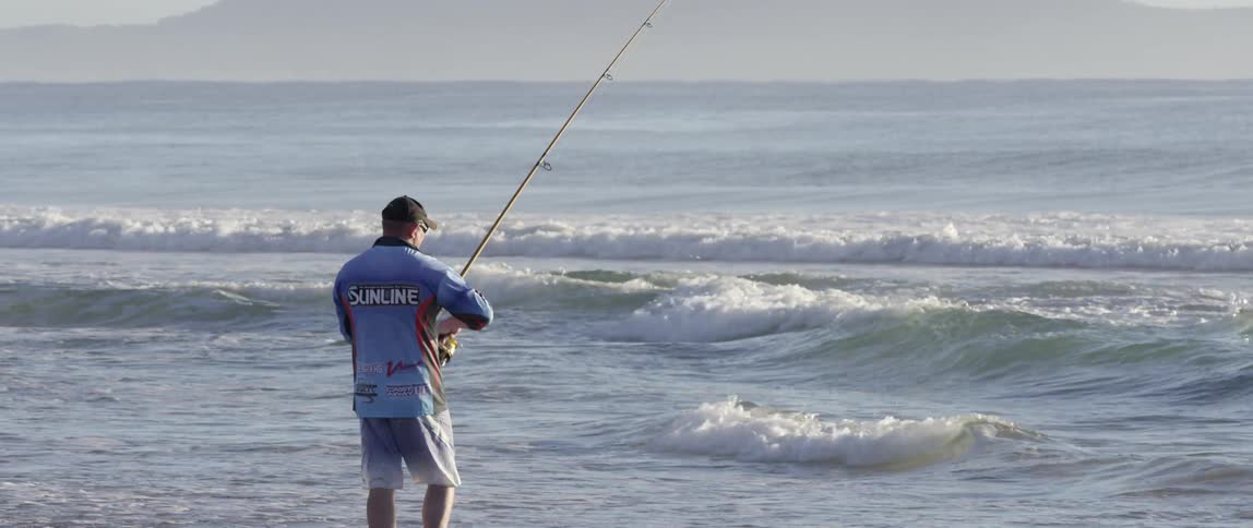 A man is fishing in the ocean