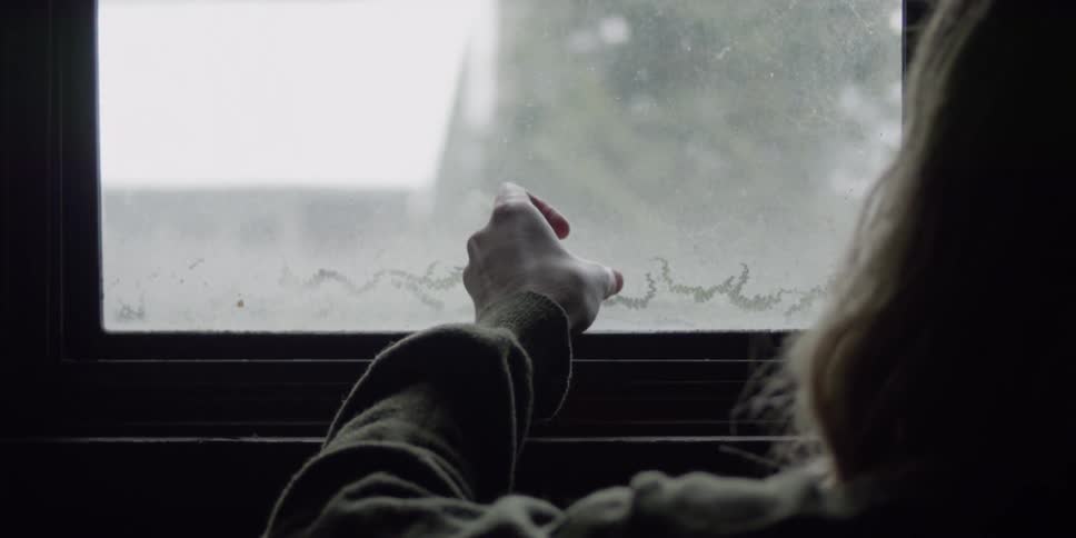 Person opens a window and points to the outside