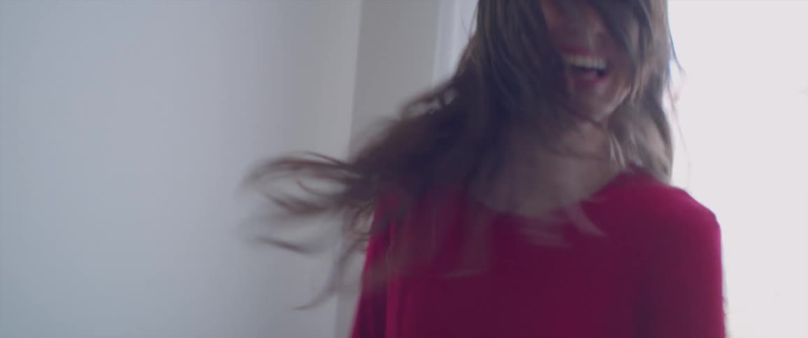 A woman in a dress dances playfully