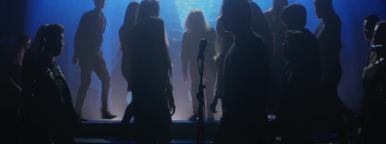 A choir walks onto a stage and risers