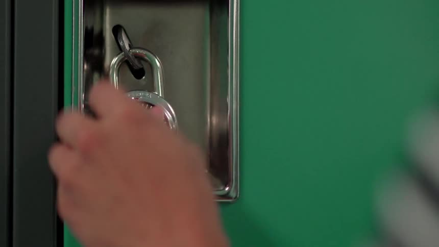 A person uses locks a green locker