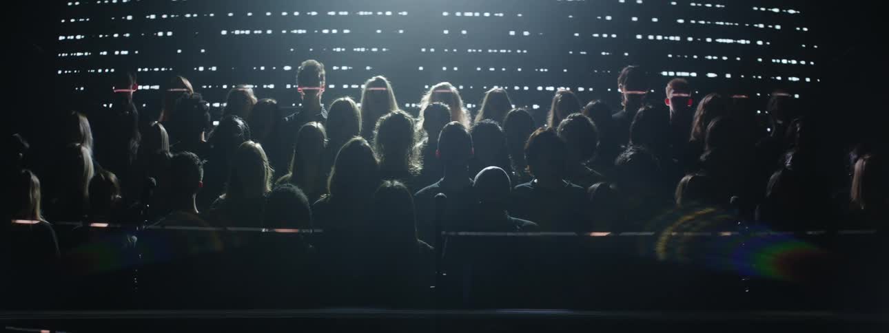 A choir is singing on a stage as lights are projected around them