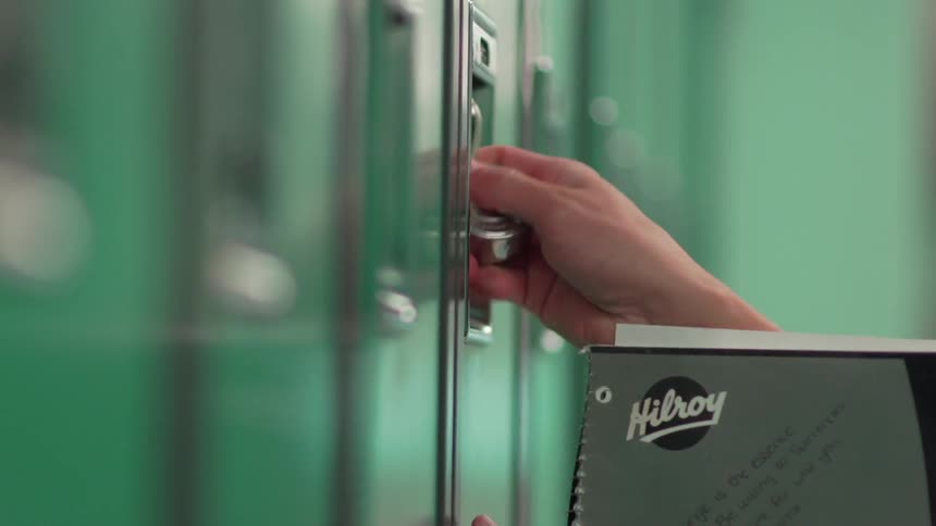 A student removes his book from the locker