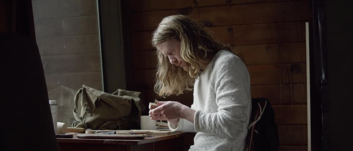 A man carves a piece of wood