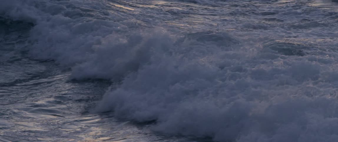 Large waves crash up onto a coastal area