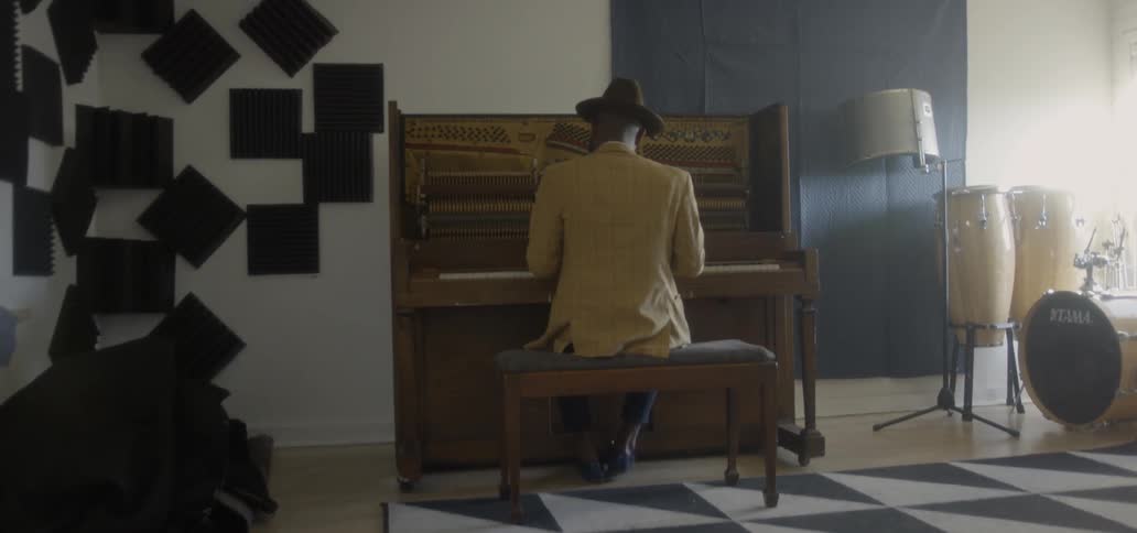 A man plays a piano in a music room