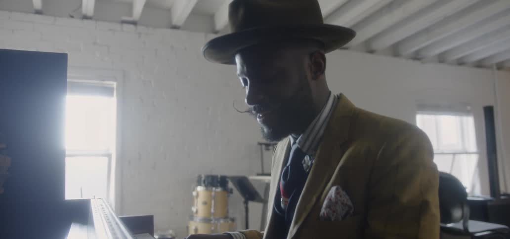 Man smiles as he plays a piano