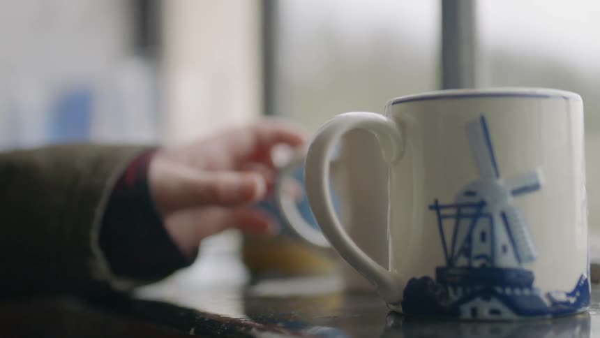 A person grabs a coffee mug