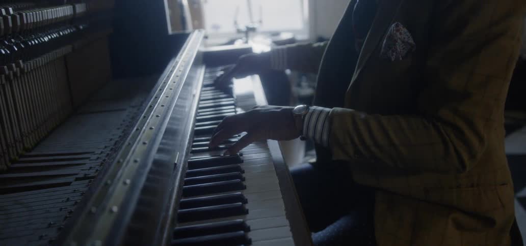 Man playing a piano in a dimly lit area