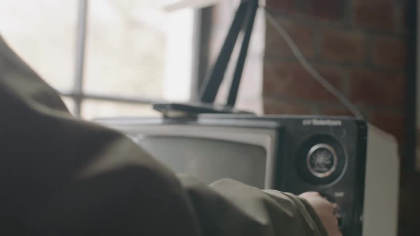 Person turns the knob on an old tv