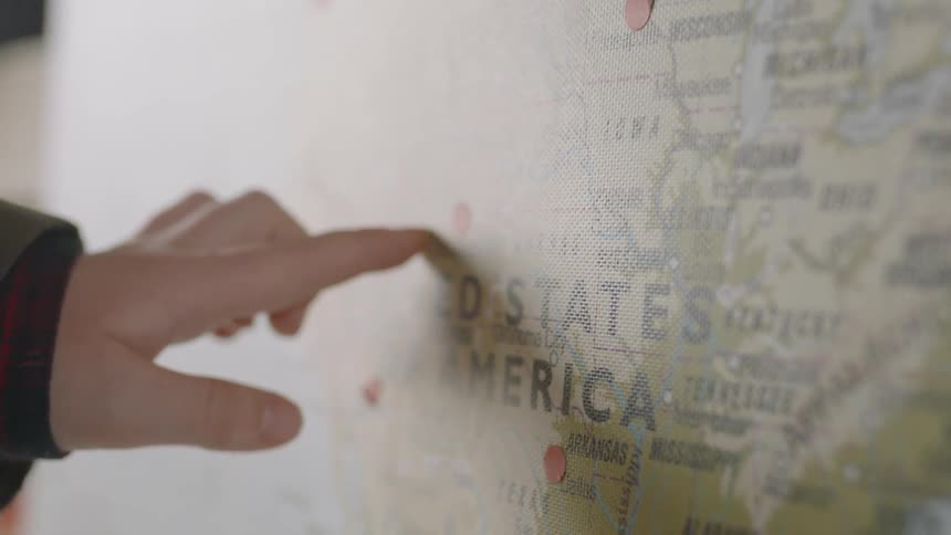 A person traces their finger across the map