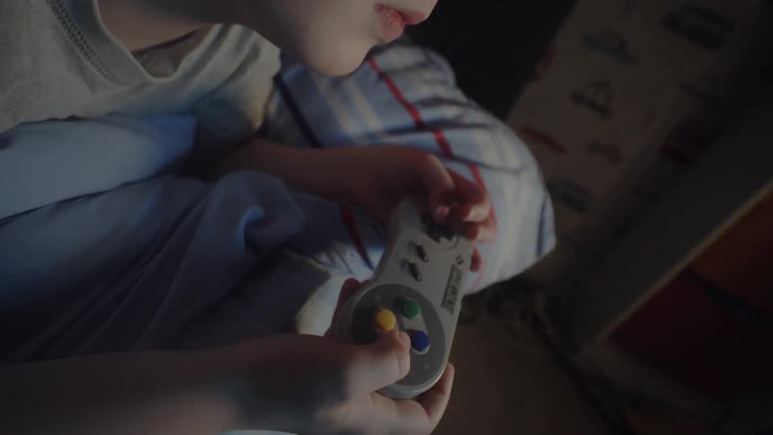 A child works a controller as he plays a video game