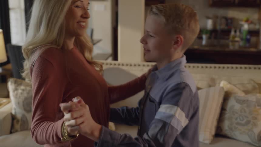 Mother is teaching her son how to dance in living room