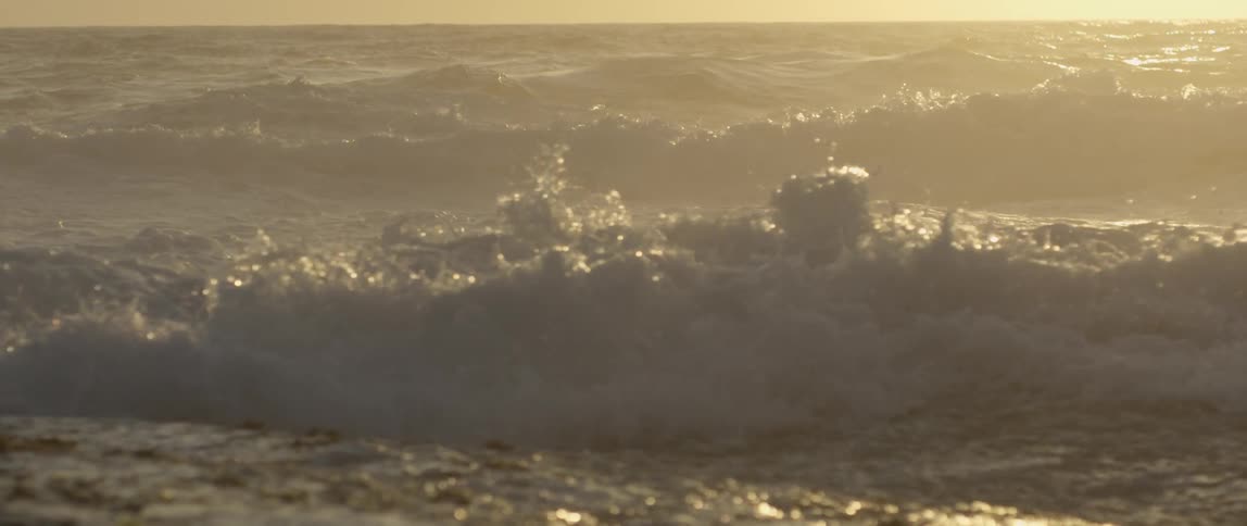 Large waves crashing into each other and reflecting sunlight
