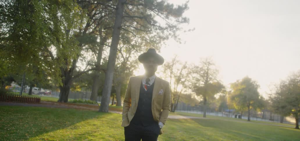 A man stands on the grass in the park
