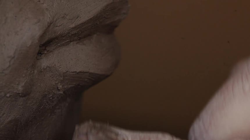 A person is sculpting the bust of a person