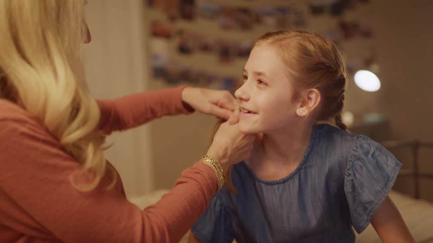 A mother braids her daughters hair