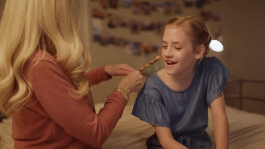 Woman braids a child's hair
