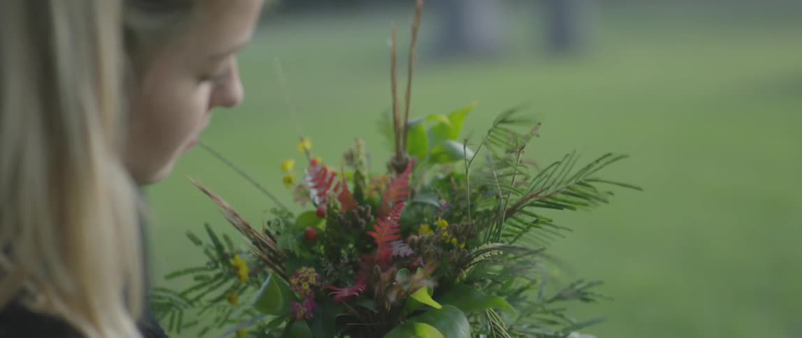 Woman examines some flowers in her hand