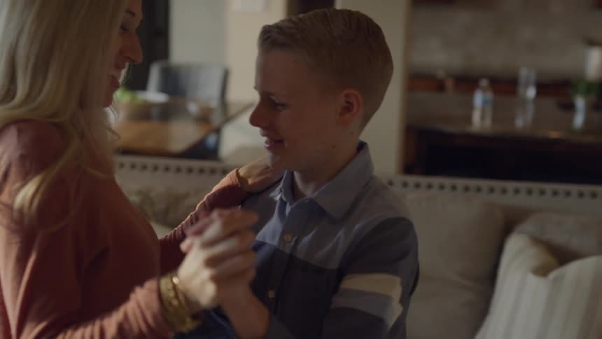 A mother is teaching a boy how to dance