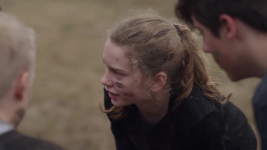 Children play football in a muddy field