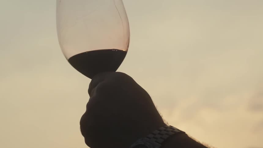 A person is tipping a glass back and forth