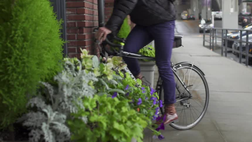 A man rides his bike and stops to enter a shop