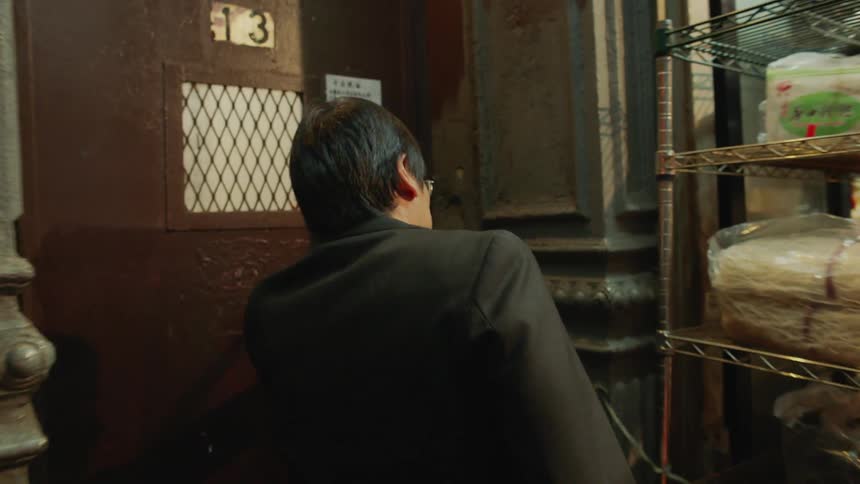 A man walks up to a building door