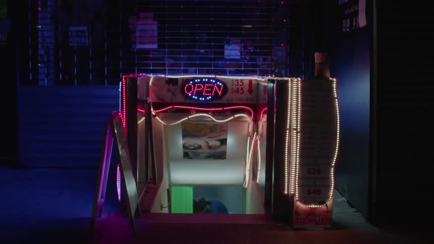 Neon lights illuminate a basement store
