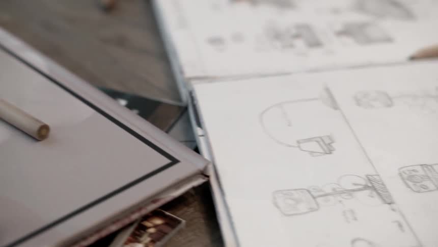 The table is covered with paper and pencils