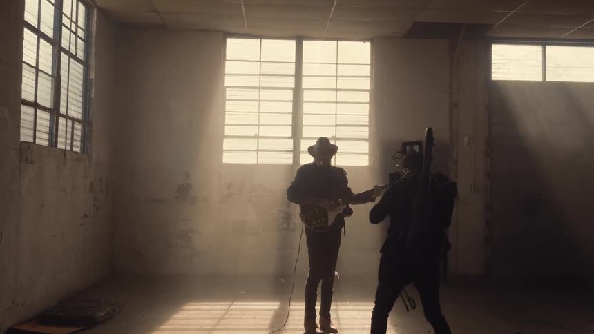 A cameraman films a musician playing guitar