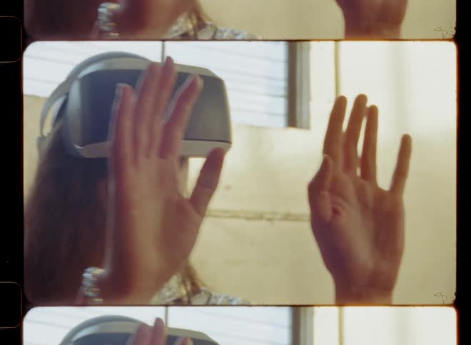 Woman wearing virtual reality headset is reaching out her hands