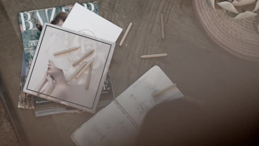 Woman sketching in notebook on table