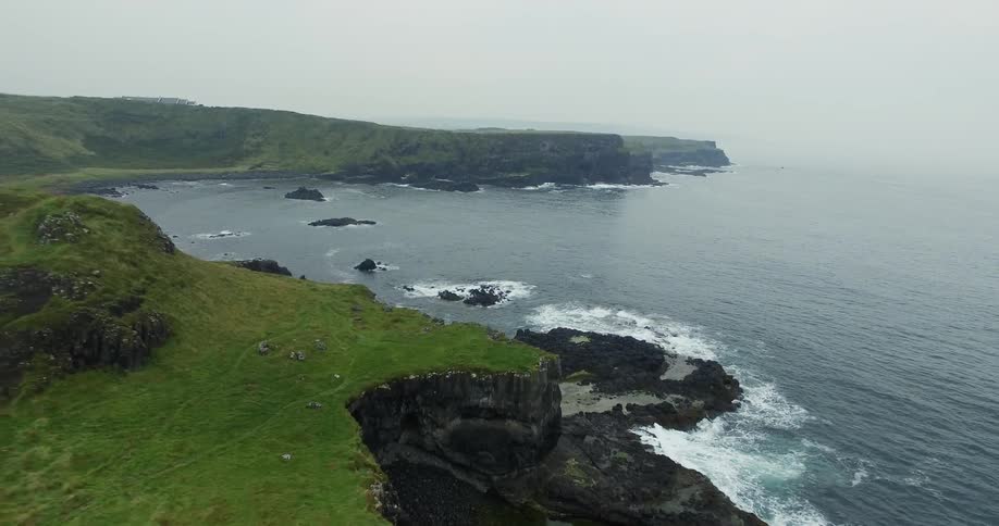 Green grass on top of mountains cliffs on the ocean coast