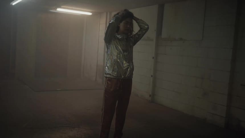 A woman stands in a room with strobing lights