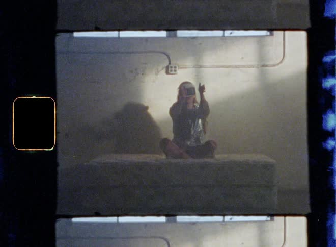 A woman is sitting on a mattress in an abandoned building using a vr headset