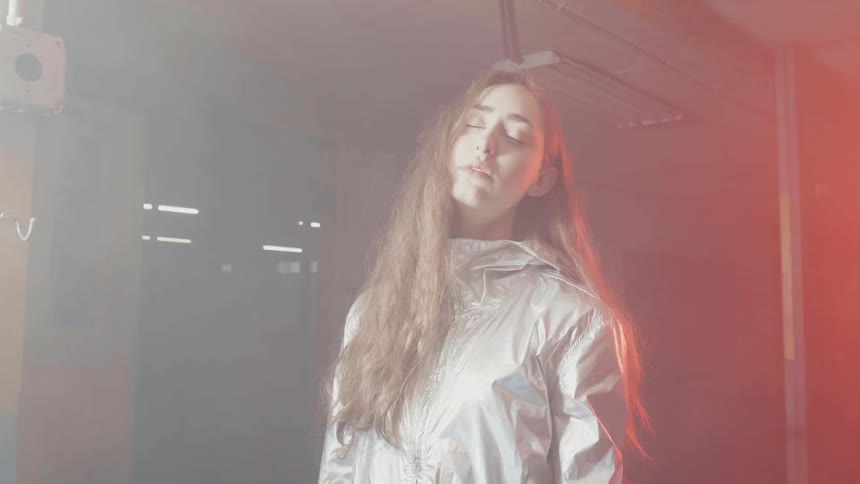 A woman has her eyes closed as the lights flash on her