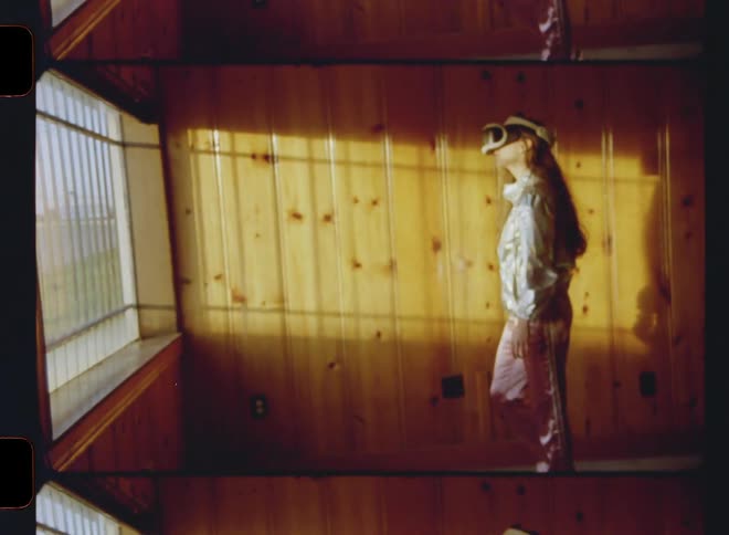 A woman wearing a virtual reality headset walks over to the window